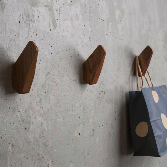 Fin Wall Hook by TIBA-TIBA - Three artistic wooden airplane fin wall hooks mounted on a concrete wall with blue polkadot bag hanging from one hook.