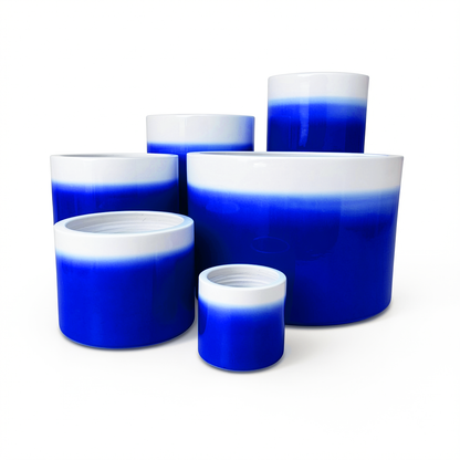 Fade Cylinder planters by TIBA-TIBA – Collection of six dark blue gradient ceramic pots of varying sizes with a glossy, glazed finish.