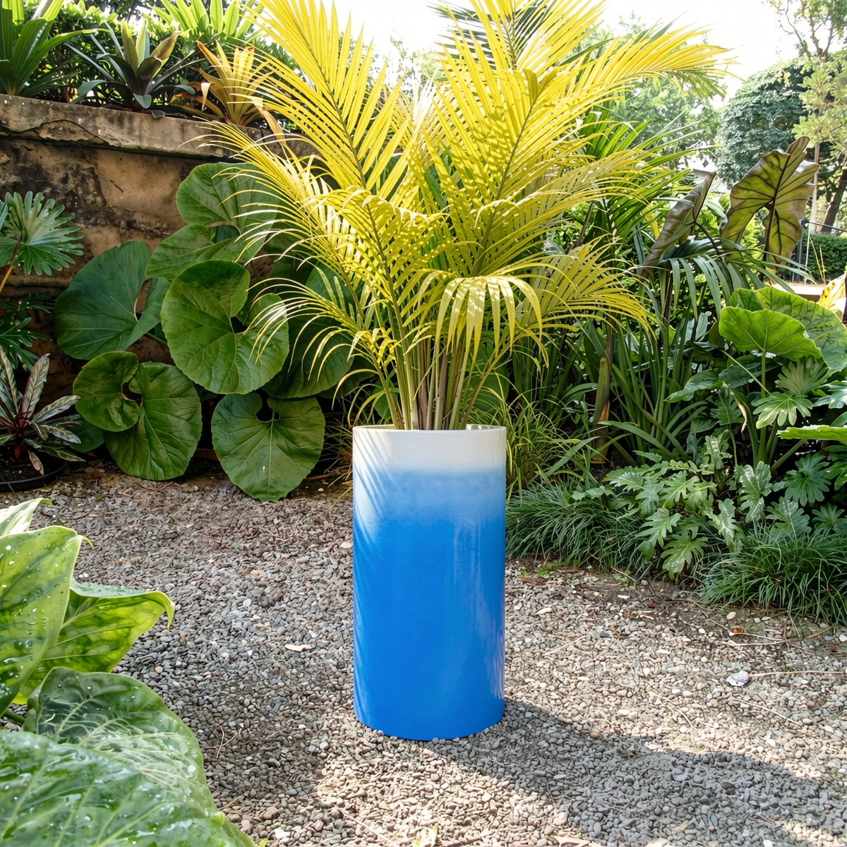 Fade Cylinder planter by TIBA-TIBA – Tall sky blue ombre planter with tropical fern plants outdoors in Balinese garden. 