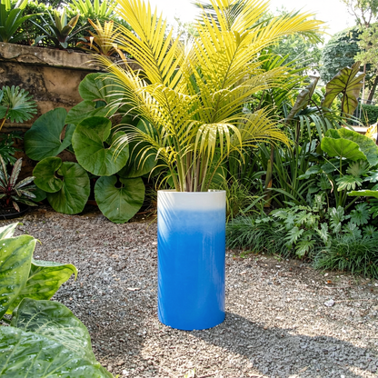 Fade Cylinder planter by TIBA-TIBA – Tall sky blue ombre planter with tropical fern plants outdoors in Balinese garden. 