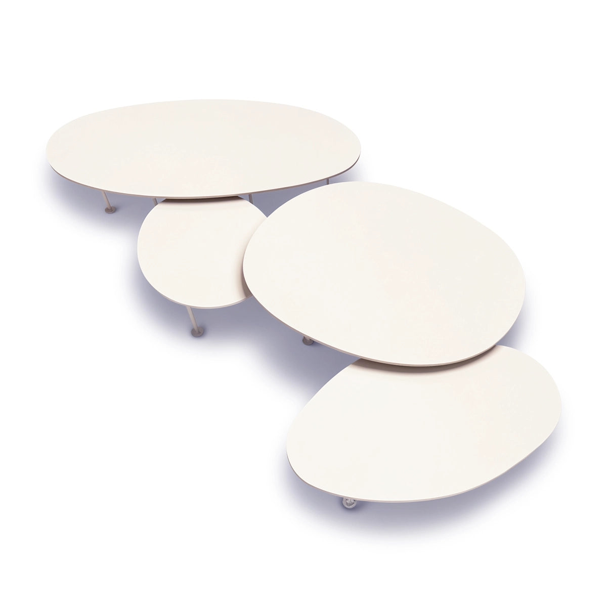 A set of four nested, organic-shaped Pebbles - Coffee Tables by TIBA-TIBA in a warm off-white finish of Dekton Aeris, resting on a white studio background. 