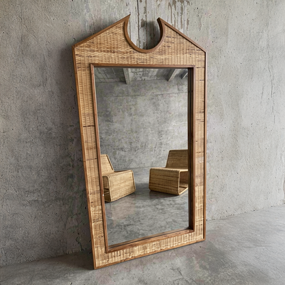 Chippendale Standing Mirror by TIBA-TIBA - Extra Large rattan and teak mirror leaning against concrete wall with Geo Rattan lounge chairs in the reflection. 