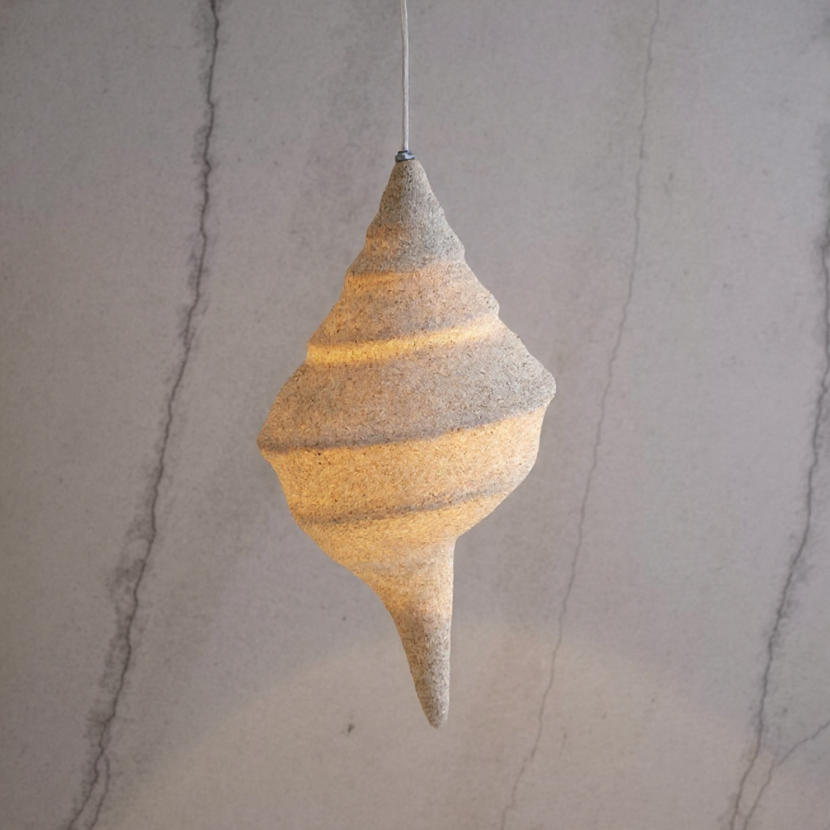 Keong Pendant Light by TIBA-TIBA - Sand coated resin shell lamp, hanging nautical lamp on cream marble background 