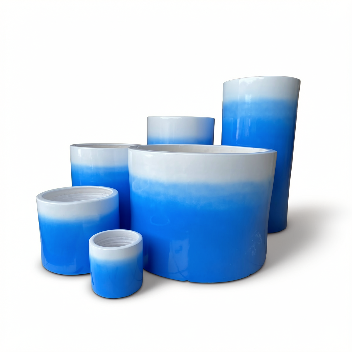 Fade Cylinder planters by TIBA-TIBA – Collection of six different sized sky blue terracotta pots with a glossy, glazed gradient to white finish.