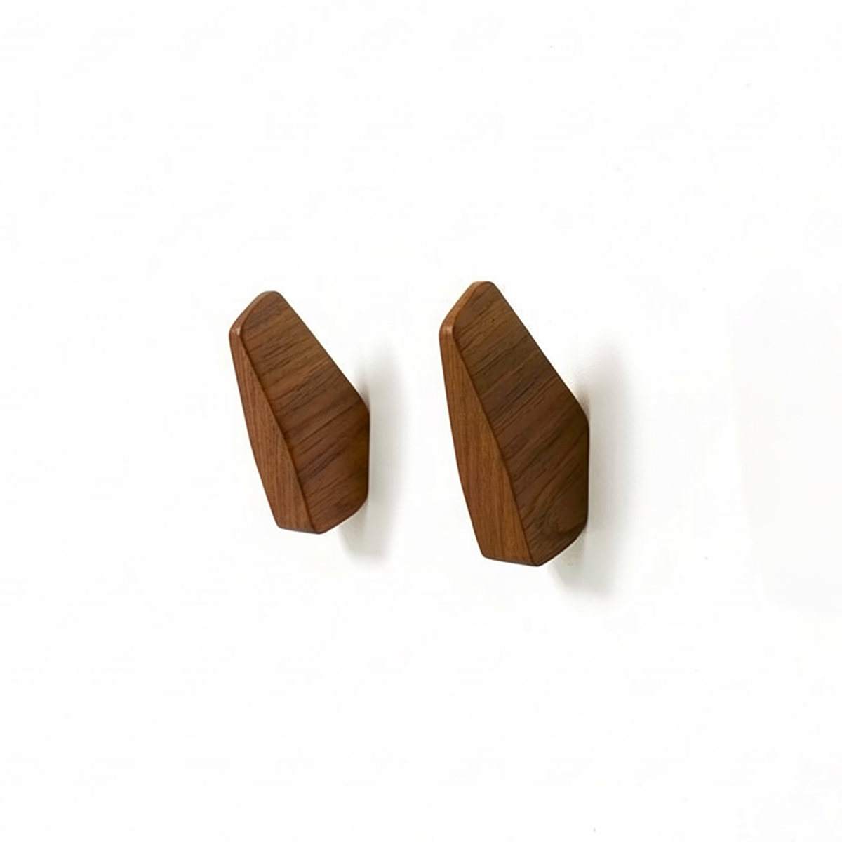 Fin Wall Hook by TIBA-TIBA - Two solid teak minimalist wooden shark tail wall hooks mounted on a white wall. 