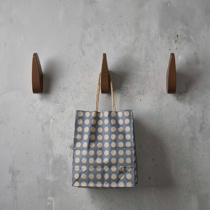 Fin Wall Hook by TIBA-TIBA - Three artistic wooden fin wall hooks mounted on a concrete wall with blue polkadot bag hanging from one hook.  