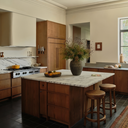 Three Sixty Stools by TIBA-TIBA – two teak wood counter stools with rotating seats at white marble central kitchen island in teak modern kitchen. 