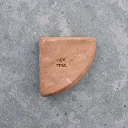 Po-Ka Pot feet by TIBA-TIBA - detail of a hand crafted terracotta pot foot wedge for outdoor plant drainage and airflow on concrete background. 
