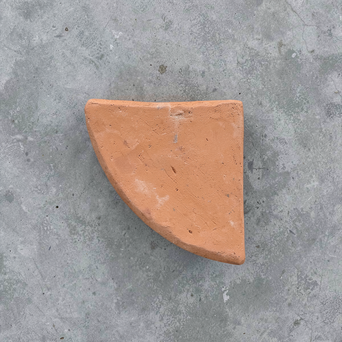 Po-Ka Pot feet by TIBA-TIBA - detail of a terracotta pot foot wedge for outdoor plant drainage and airflow on concrete background. 