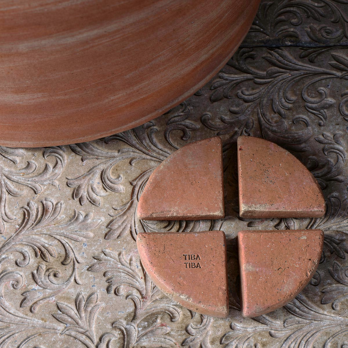Po-Ka Pot feet by TIBA-TIBA - detail of a set of four terracotta pot feet with an outdoor terracotta planter on decorative concrete. 