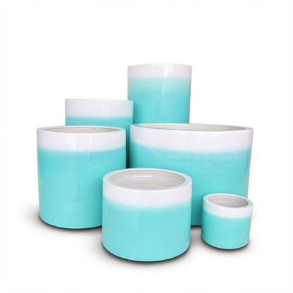 Fade Cylinder planters by TIBA-TIBA – Group of six glossy turquoise ombre ceramic pots of varying sizes.