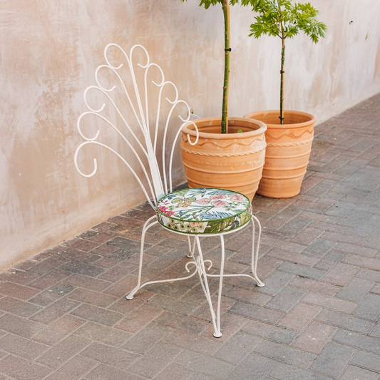 Plume Chair by TIBA-TIBA – white metal peacock chair with decorative curly steel back in terracotta outdoor setting.