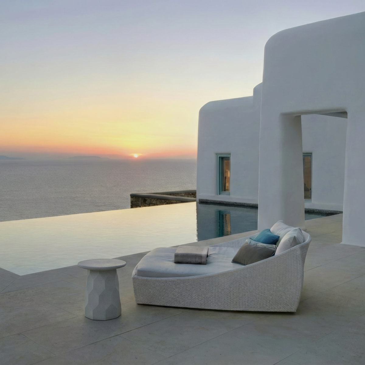 Jetty Side Table by TIBA-TIBA - white terrazzo outdoor side table with hexagon motif with white rattan sofa by pool at cliffside Mykonos villa. 